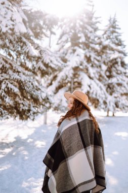 Genç bir kadın kar ormanında kış havasının tadını çıkarıyor. Soğuk hava. Kış modası, tatiller, dinlenme, seyahat konsepti.