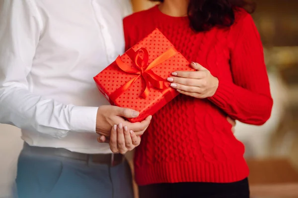 Exchange of gifts.  Young couple in love offering gift to each other for valentine day or birthday. Romantic day. Winter holidays.