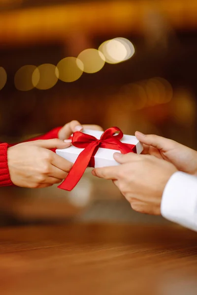 Exchange of gifts.  Young couple in love offering gift to each other for valentine day or birthday. Romantic day. Winter holidays.