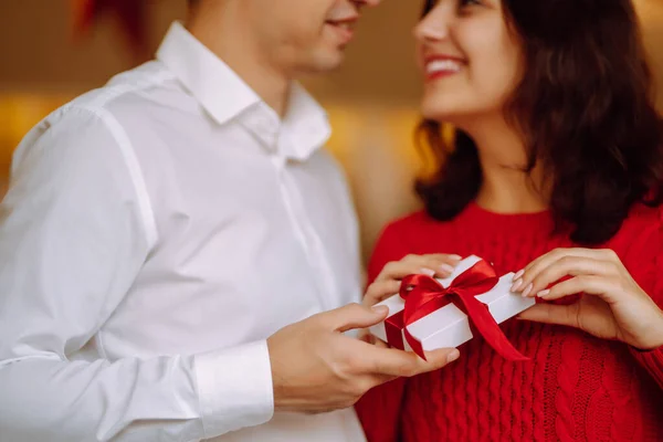 Exchange of gifts.  Young couple in love offering gift to each other for valentine day or birthday. Romantic day. Winter holidays.