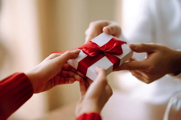 Exchange of gifts.  Young couple in love offering gift to each other for valentine day or birthday. Romantic day. Winter holidays.