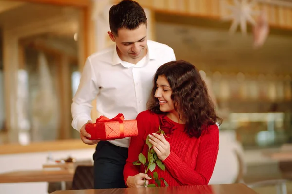 Exchange of gifts.  Young couple in love offering gift to each other for valentine day or birthday. Romantic day. Winter holidays.