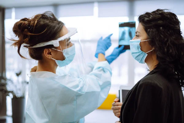 Una Doctora Visera Guantes Protectores Discutiendo Una Radiografía Médico Examina — Foto de Stock