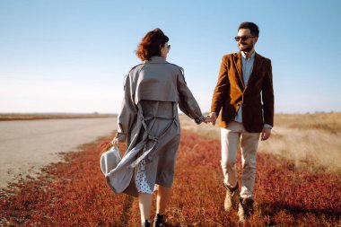 Genç çift bahar boyunca parkta yürür ve sarılırlar. Birlikte eğleniyoruz. Gençlik, aşk ve yaşam tarzı kavramı.