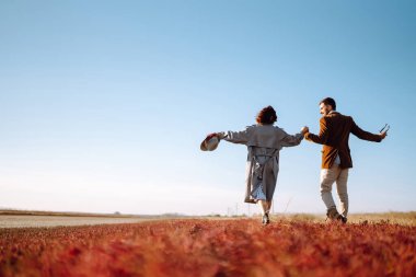 Genç çift bahar boyunca parkta yürür ve sarılırlar. Birlikte eğleniyoruz. Gençlik, aşk ve yaşam tarzı kavramı.