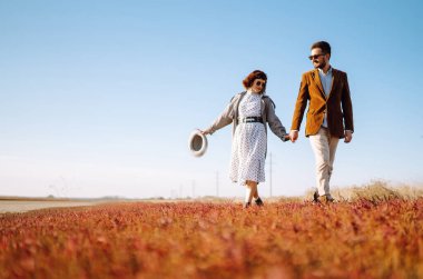 Genç çift bahar boyunca parkta yürür ve sarılırlar. Birlikte eğleniyoruz. Gençlik, aşk ve yaşam tarzı kavramı.