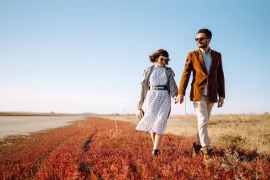 Genç çift bahar boyunca parkta yürür ve sarılırlar. Birlikte eğleniyoruz. Gençlik, aşk ve yaşam tarzı kavramı.