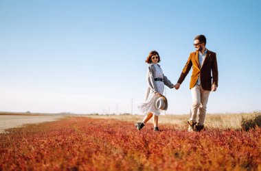 Genç çift bahar boyunca parkta yürür ve sarılırlar. Birlikte eğleniyoruz. Gençlik, aşk ve yaşam tarzı kavramı.