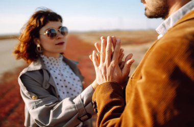 El ele tutuşan bir çift. Birlikte eğleniyoruz. Hipster çift bahar aylarında parkta yürür ve sarılırlar..