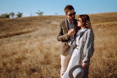 Tarz sahibi ve sevecen bir çift dışarıda eğleniyor. Genç çift yürüyor ve sarılıyor. İlkbahar.