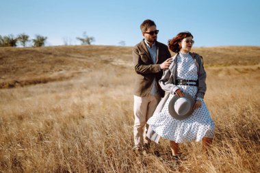 Tarz sahibi ve sevecen bir çift dışarıda eğleniyor. Genç çift yürüyor ve sarılıyor. İlkbahar.
