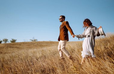 Tarz sahibi ve sevecen bir çift dışarıda eğleniyor. Genç çift yürüyor ve sarılıyor. İlkbahar.