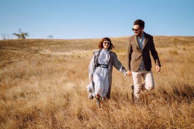 Tarz sahibi ve sevecen bir çift dışarıda eğleniyor. Genç çift yürüyor ve sarılıyor. İlkbahar.