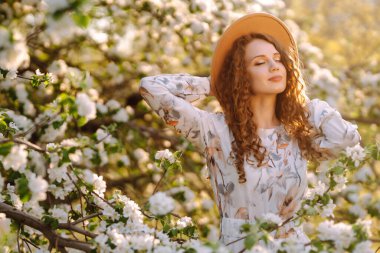 Çiçek açan bahçede poz veren güzel romantik bir kadın. Gençlik, aşk, moda ve yaşam tarzı kavramı.