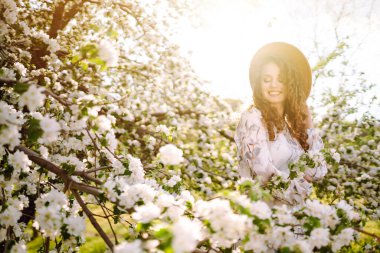 Çiçek açan bahçede poz veren güzel romantik bir kadın. Gençlik, aşk, moda ve yaşam tarzı kavramı.