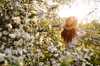 Çiçek açan bahçede poz veren güzel romantik bir kadın. Gençlik, aşk, moda ve yaşam tarzı kavramı.