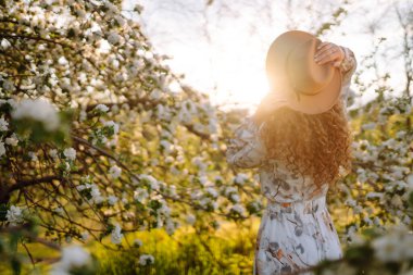 Çiçek açan bahçede poz veren güzel romantik bir kadın. Gençlik, aşk, moda ve yaşam tarzı kavramı.
