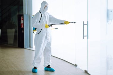 Koruyucu giysinin içindeki bir dezenfektan ve maske ofiste dezenfektan püskürtür. COVID-19 hastalığını koruma amaçlı. Yüzeyleri olan zatürree virüsünün yayılmasının önlenmesi.