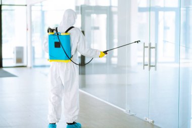 Koruyucu giysinin içindeki bir dezenfektan ve maske ofiste dezenfektan püskürtür. COVID-19 hastalığını koruma amaçlı. Yüzeyleri olan zatürree virüsünün yayılmasının önlenmesi.