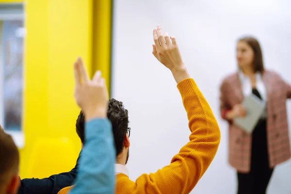 Business people raising hand up to ask question with speaker, to agree or vote for comments in seminar conference. Business group meeting seminar training concept.