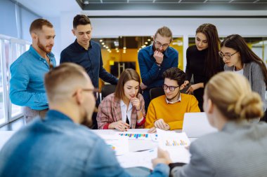 Yaratıcı ofiste birlikte çalışan bir grup genç iş adamı. Gençler ofiste yeni bir iş projesini tartışıyorlar. Takım çalışmasında planlama, analiz, işbirliği.
