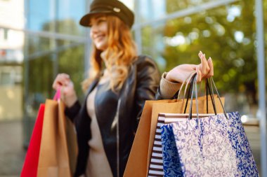 Alışveriş torbalarıyla sokakta yürüyen modacı kadın. Bahar atlaması. Satın almalar, Kara Cuma, indirimler, satış konsepti.