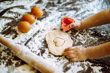 Küçük bir çocuk kalp hamurunu şekillendirir. Paskalya pastası hazırlığı. Çocuk sanat projesi, çocuklar için bir zanaat..