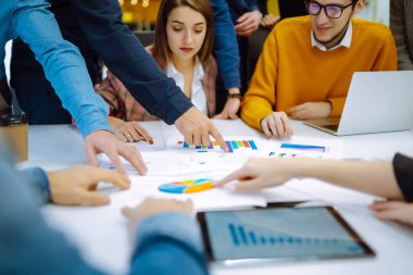 Bir grup modern insan proje üzerinde birlikte çalışıyor. İş arkadaşları finansal sonuç incelemesi hakkında tartıştılar. Fikirlerini paylaştılar. Beyin fırtınası takım çalışmasında işbirliği yaptılar. Planlama, analiz.