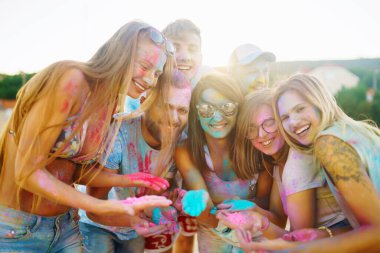 Group of people have fun at the holi festival of colors. Smiling faces in colorful powder. Celebrating traditional indian spring holiday. Party, vacation concept. Friendship and celebration concept. clipart