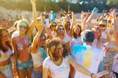 Holi renk festivalinde bir grup insan eğleniyor. Renkli toz içinde gülümseyen yüzler. Geleneksel Hint bahar tatilini kutluyoruz. Parti, tatil konsepti. Arkadaşlık ve kutlama konsepti.