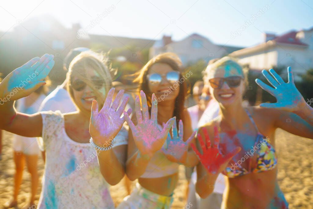 Group of people have fun at the holi festival of colors. Smiling faces in colorful powder. Celebrating traditional indian spring holiday. Party, vacation concept. Friendship and celebration concept.