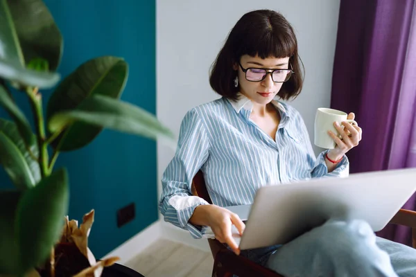 Mladá Žena Volné Noze Sedět Moderní Pohovce Psaní Notebook Obývacím — Stock fotografie