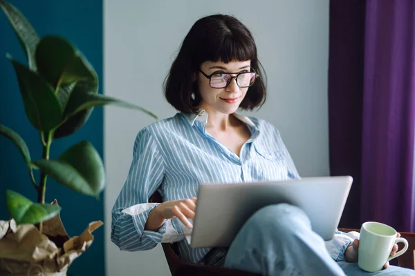 Mladá Žena Volné Noze Sedět Moderní Pohovce Psaní Notebook Obývacím — Stock fotografie