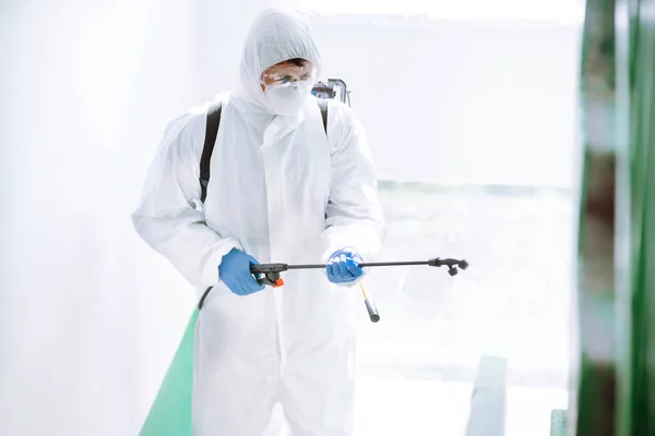 보호용 양복을 사람은 도시에서 전염병처럼 퍼지는 코로나 바이러스를 예방하기 스프레이 — 스톡 사진