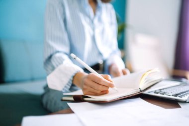 Evde genç bir kadın defter yazıp onunla çalışıyor. Serbest çalışan ve evde karantinada çalışırken notlar alan biri. Sosyal uzaklık. Kişisel İzolasyon