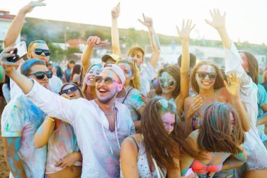 Bir grup arkadaş eğleniyor, Holi festivalinde dans ediyorlar. Bahar tatili plaj partisi. Geleneksel Hint bahar tatilini kutluyoruz. Arkadaşlık, Boş zaman, Tatil, Beraberlik.