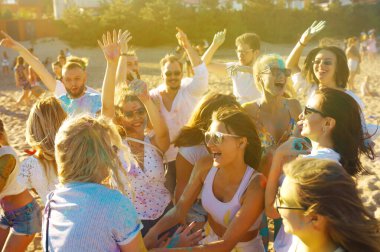 Bir grup arkadaş eğleniyor, Holi festivalinde dans ediyorlar. Bahar tatili plaj partisi. Geleneksel Hint bahar tatilini kutluyoruz. Arkadaşlık, Boş zaman, Tatil, Beraberlik.