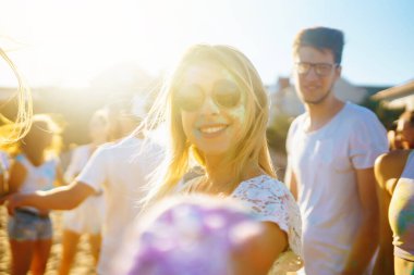 Bir grup arkadaş eğleniyor, Holi festivalinde dans ediyorlar. Bahar tatili plaj partisi. Geleneksel Hint bahar tatilini kutluyoruz. Arkadaşlık, Boş zaman, Tatil, Beraberlik.