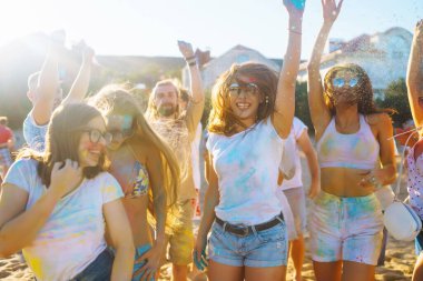 Bir grup arkadaş eğleniyor, Holi festivalinde dans ediyorlar. Bahar tatili plaj partisi. Geleneksel Hint bahar tatilini kutluyoruz. Arkadaşlık, Boş zaman, Tatil, Beraberlik.