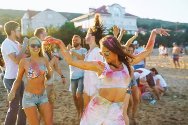 Bir grup arkadaş eğleniyor, Holi festivalinde dans ediyorlar. Bahar tatili plaj partisi. Geleneksel Hint bahar tatilini kutluyoruz. Arkadaşlık, Boş zaman, Tatil, Beraberlik.
