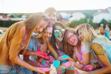 Bir grup arkadaş eğleniyor, Holi festivalinde dans ediyorlar. Bahar tatili plaj partisi. Geleneksel Hint bahar tatilini kutluyoruz. Arkadaşlık, Boş zaman, Tatil, Beraberlik.