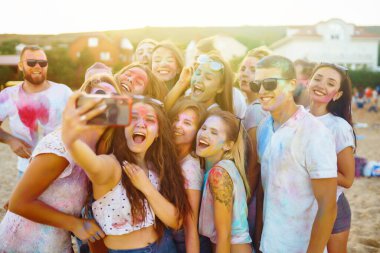 Bir grup arkadaş eğleniyor, Holi festivalinde dans ediyorlar. Bahar tatili plaj partisi. Geleneksel Hint bahar tatilini kutluyoruz. Arkadaşlık, Boş zaman, Tatil, Beraberlik.