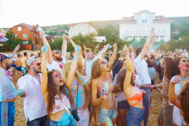 Bir grup arkadaş eğleniyor, Holi festivalinde dans ediyorlar. Bahar tatili plaj partisi. Geleneksel Hint bahar tatilini kutluyoruz. Arkadaşlık, Boş zaman, Tatil, Beraberlik.