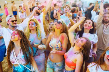 Bir grup arkadaş eğleniyor, Holi festivalinde dans ediyorlar. Bahar tatili plaj partisi. Geleneksel Hint bahar tatilini kutluyoruz. Arkadaşlık, Boş zaman, Tatil, Beraberlik.