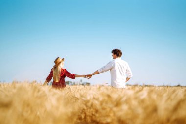 Buğday tarlasında birbirini seven bir çift. Birlikte eğleniyoruz. Gençlik, aşk ve yaşam tarzı kavramı.