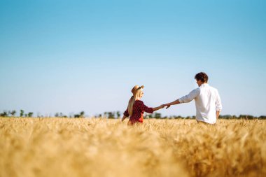 Buğday tarlasında birbirini seven bir çift. Birlikte eğleniyoruz. Gençlik, aşk ve yaşam tarzı kavramı.