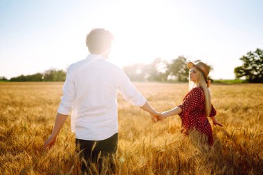 Buğday tarlasında birbirini seven bir çift. Birlikte eğleniyoruz. Gençlik, aşk ve yaşam tarzı kavramı.
