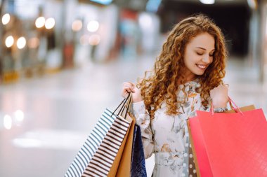 Modern alışveriş merkezinde çok renkli çantaları olan şık bir kadın. Tüketim sevinci. Tüketim, satış, alım, alışveriş, yaşam tarzı konsepti.
