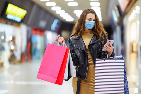 Mujer Joven Máscara Médica Protectora Con Bolsas Compras Usando Teléfono — Foto de Stock