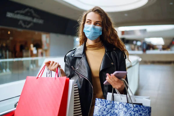 Mujer Joven Máscara Médica Protectora Con Bolsas Compras Usando Teléfono — Foto de Stock